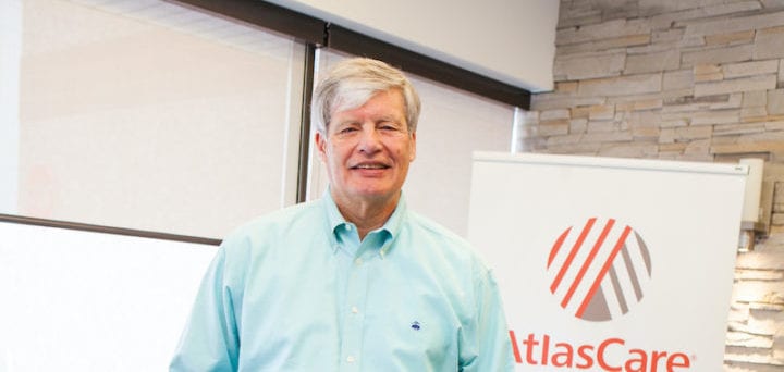 Photo of Roger Grochmal standing in front of an AtlasCare banner